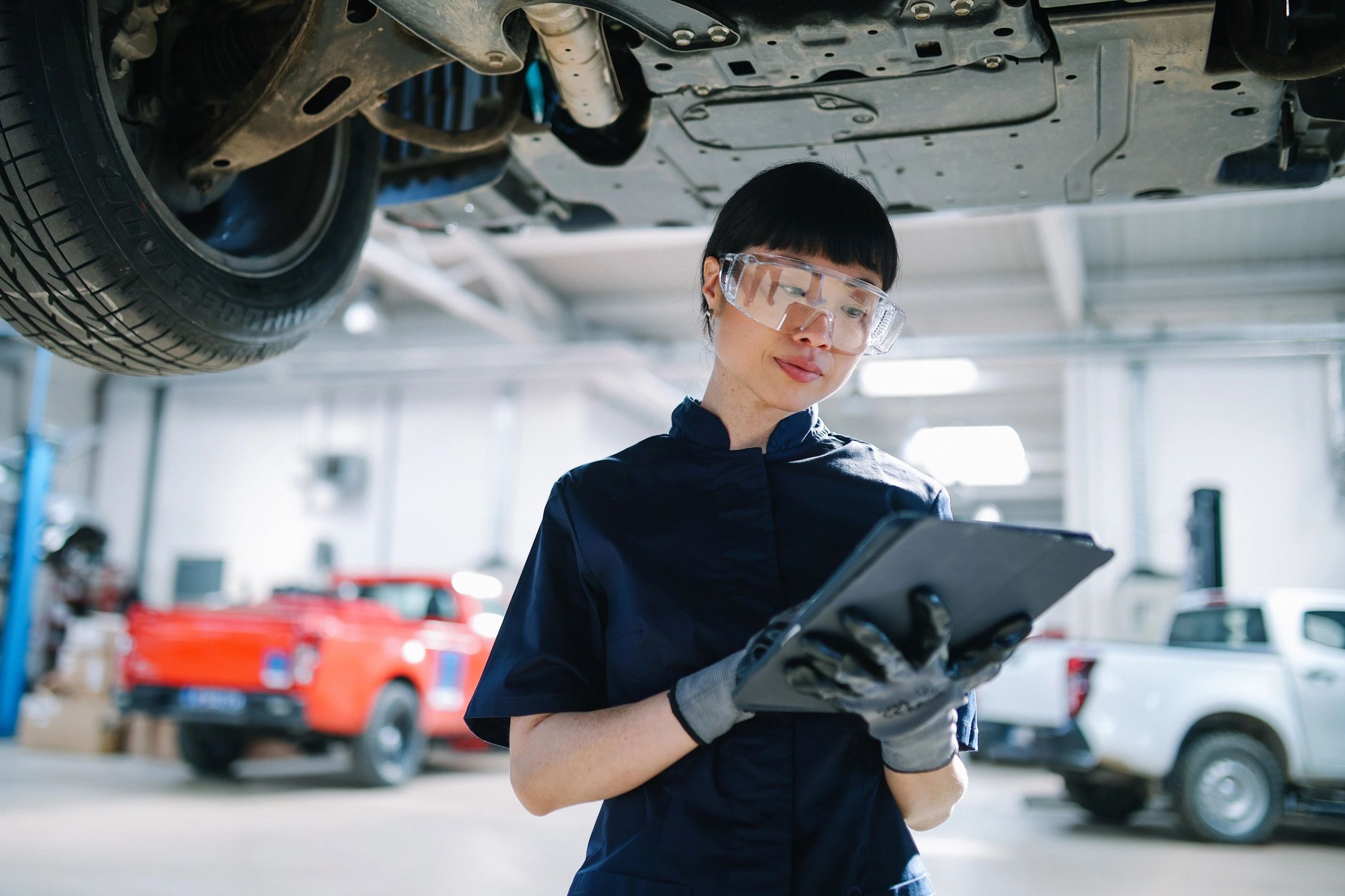 Mechanic using a tablet during vehicle inspection