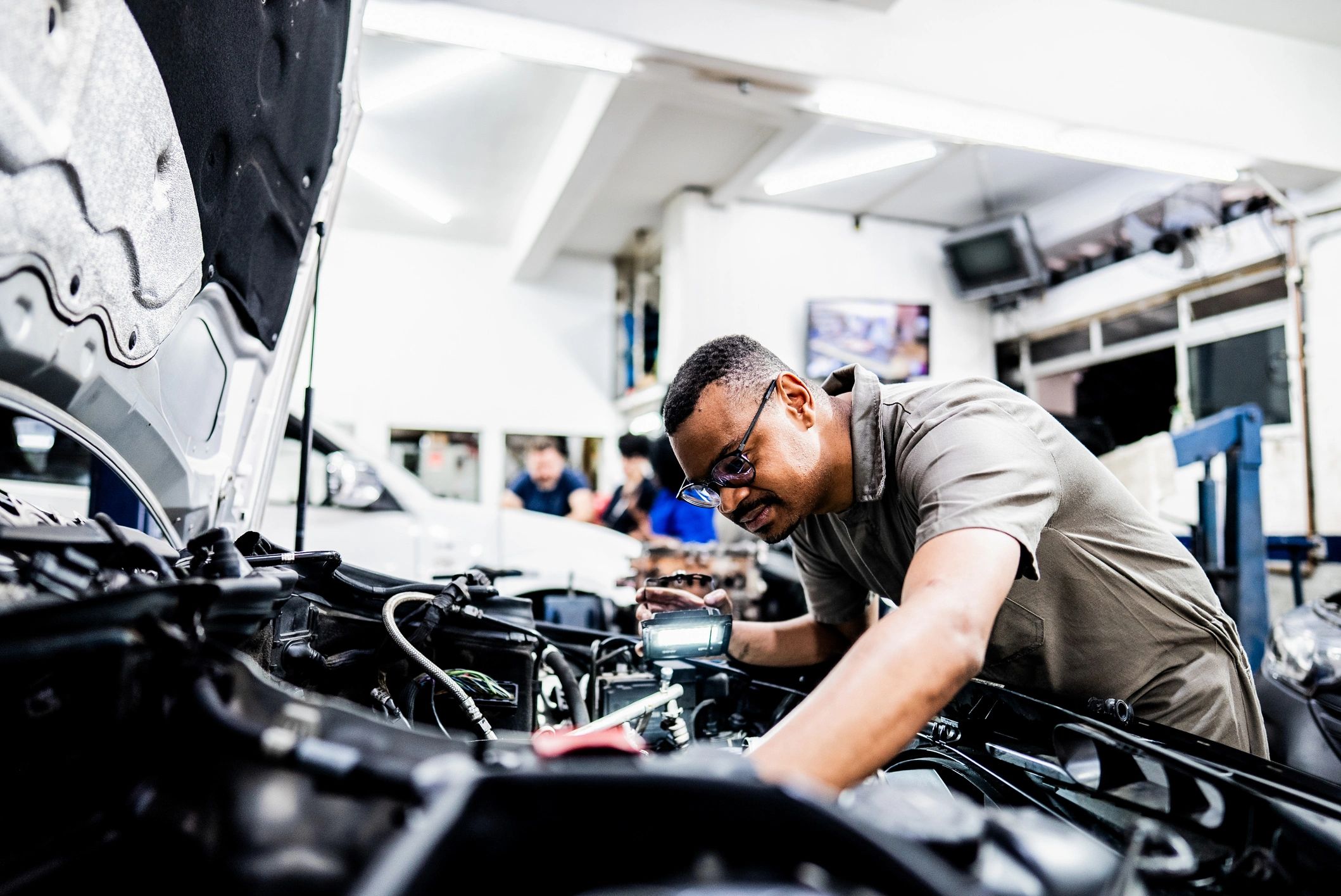 ASE-certified mechanic inspecting a vehicle in a modern auto repair bay